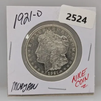 1921-D Morgan silver dollar housed in a cardboard flip, displaying the obverse profile of Liberty.