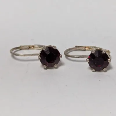 Pair of vintage silver-tone leverback drop earrings featuring round prong-set dark red stones, possibly garnet or glass.