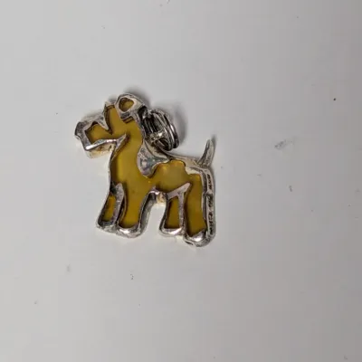 Vintage Scottish Terrier dog pendant featuring a silver-tone frame with yellow amber-style resin infill.