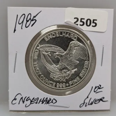 1985 Engelhard Prospector American Eagle one troy ounce .999 fine silver round in a cardboard coin flip holder.