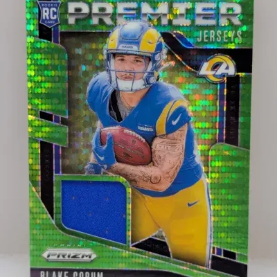 Panini Prizm Blake Corum Premier Jerseys green pulsar parallel rookie card featuring an embedded blue jersey swatch.