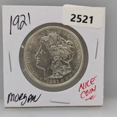 1921 Morgan silver dollar coin housed in a cardboard flip holder.