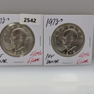 Pair of 1973-S Eisenhower 40% silver dollars, individually packaged in protective coin flips.