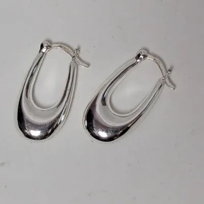 Pair of modern polished sterling silver oval hoop earrings with snap-bar closures.