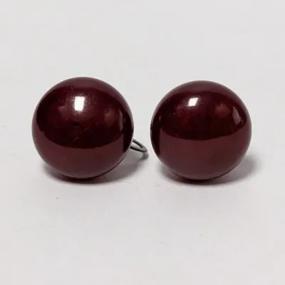 Pair of vintage deep burgundy round ball clip-on earrings with a glossy finish.