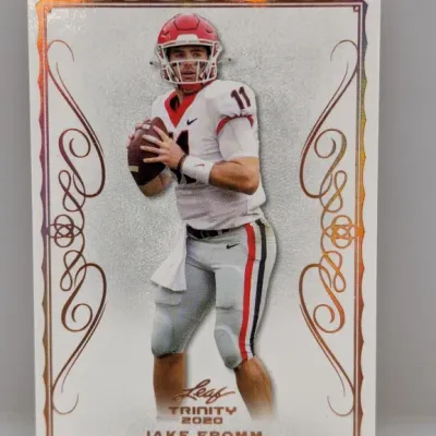 2020 Leaf Trinity Jake Fromm football trading card in excellent condition with ornate metallic foil border accents.