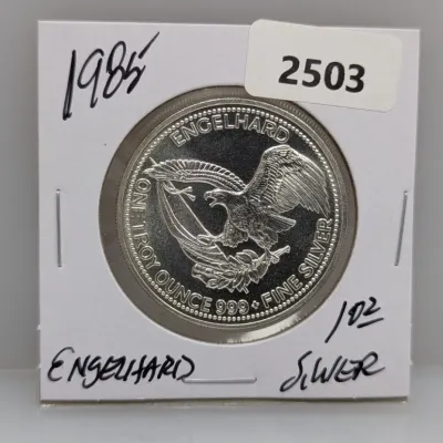 1985 Engelhard Prospector 1 troy ounce .999 fine silver round in a cardboard flip holder.