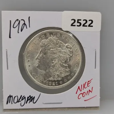 1921 Morgan silver dollar, housed in a cardboard 2x2 coin flip holder.