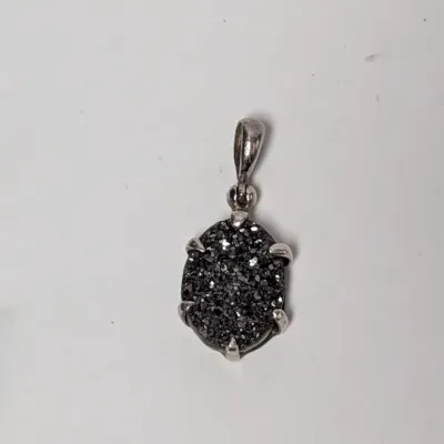 Oval dark druzy pendant with a prong setting and silver-tone bail.