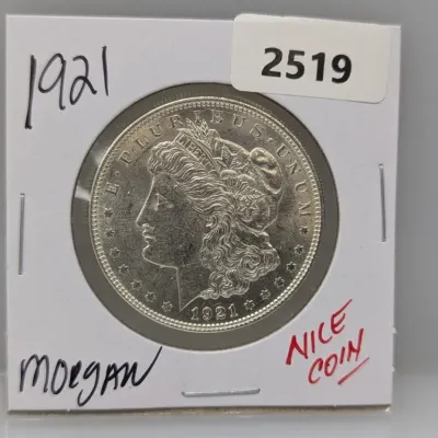 1921 Morgan silver dollar coin housed in a protective paper flip cardboard holder.