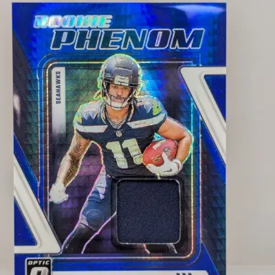 2023 Panini Donruss Optic Rookie Phenom Jaxon Smith-Njigba blue scope parallel trading card with jersey memorabilia swatch.