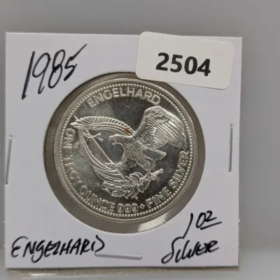 1985 Engelhard 1 troy ounce .999 fine silver round in a cardboard flip holder featuring an American eagle design.