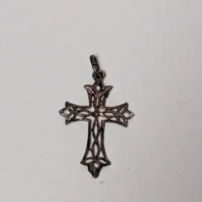 Openwork filigree cross pendant in oxidized sterling silver or pewter with intricate scroll details.