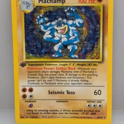 1st Edition Machamp holo Pokémon trading card (8/102) from the 1999 Base Set, showing light surface scratching on the foil art.