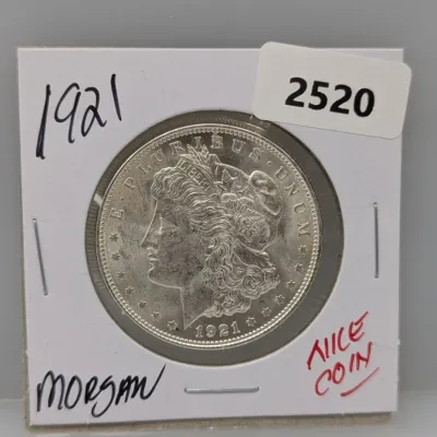 1921 Morgan silver dollar coin housed in a cardboard flip holder.