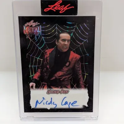 Leaf Metal trading card featuring a Nicolas Cage autograph, encased in a sealed protective acrylic display case.