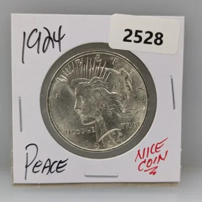 1924 Peace silver dollar coin in a protective cardboard flip holder.