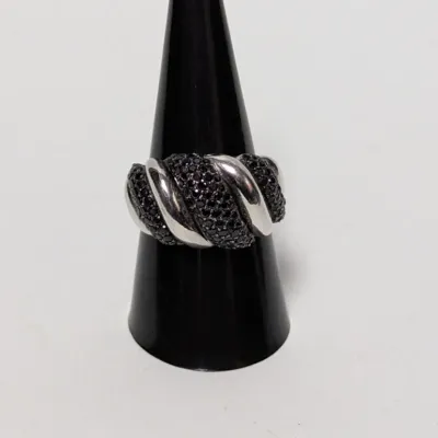 Sterling silver twist band ring featuring pavé-set black spinach stones or black cubic zirconia, presented on a black cone display stand.