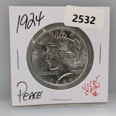 1924 Peace silver dollar coin in a cardboard flip holder.