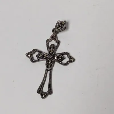 Vintage sterling silver cross pendant set with marcasite stones featuring an ornate filigree design.