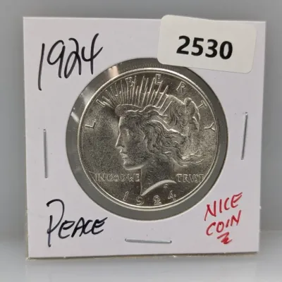 1924 Peace silver dollar housed in a cardboard coin flip holder.