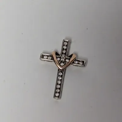 Two-tone silver and rose gold cross pendant set with clear stones, featuring a heart detail at the intersection.