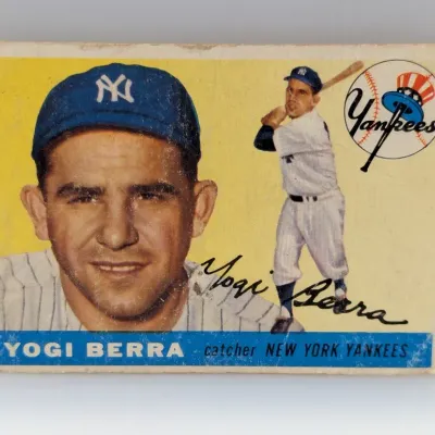 1954 Topps #17 Yogi Berra baseball card featuring a portrait and action shot of the New York Yankees catcher against a yellow background.