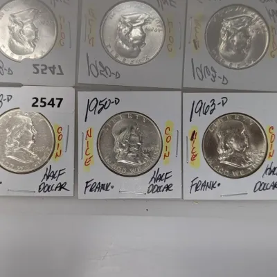 Collection of US silver coins in cardboard flips, including Franklin half dollars dated 1948-D, 1950-D, and 1963-D.