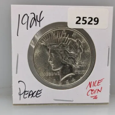 1924 Peace silver dollar coin presented in a protective cardboard flip holder.