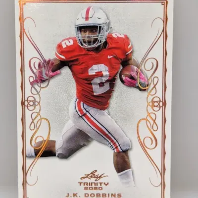 2020 Leaf Trinity J.K. Dobbins football trading card featuring ornate bronze foil border accents.
