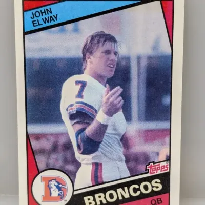 1984 Topps John Elway rookie football card (#63), featuring the Denver Broncos quarterback in fair to good condition.