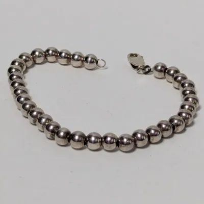 Sterling silver bead bracelet featuring polished round beads and a lobster claw clasp.