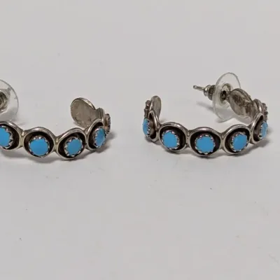 Pair of Native American style sterling silver and petit point turquoise half-hoop post earrings with plastic disc backings.