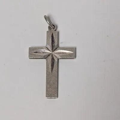 Vintage sterling silver cross pendant with diamond-cut starburst engraving at the center.