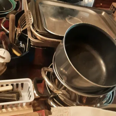 Large collection of assorted cookware, including stainless steel stock pots with lids, baking sheets, non-stick saucepans, and kitchen...