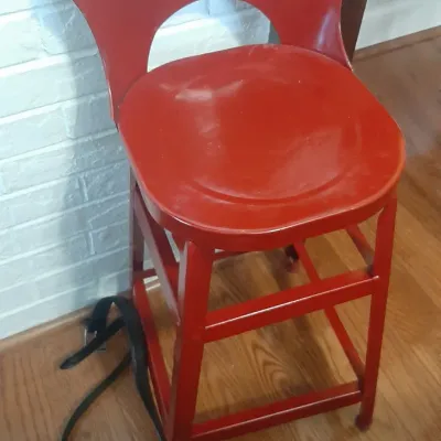 Vintage red metal high chair or counter stool featuring a heart-shaped backrest and a square base with stretchers.