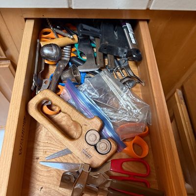 Sale Photo Thumbnail #43: Kitchen drawer filled with miscellaneous gadgets and tools, including a wooden Wüsthof Trident knife sharpener, scissors, tea infusers, and a manual can opener.