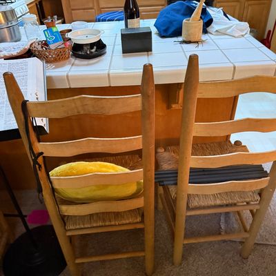 Sale Photo Thumbnail #25: Pair of rustic ladder-back wooden dining chairs with woven rush seats, positioned at a tiled kitchen counter.