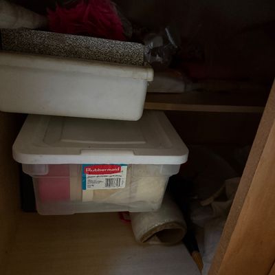 Sale Photo Thumbnail #52: Rubbermaid clear plastic storage tote with lid stored inside a wooden cabinet alongside additional household supplies.