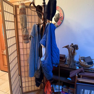 Sale Photo Thumbnail #12: Vintage bentwood coat rack holding various jackets and hats, standing next to a shoji-style folding room divider.
