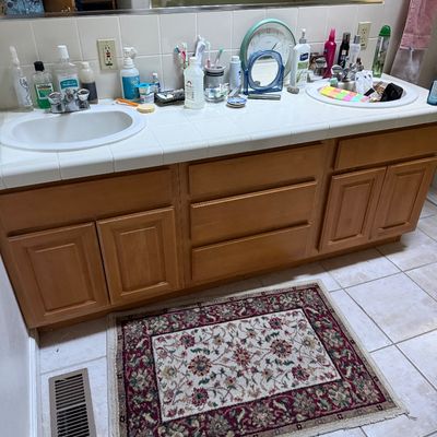 Sale Photo Thumbnail #59: Small oriental-style accent rug featuring a cream field with floral motifs and a burgundy border, placed in front of a double bathroom vanity.