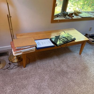 Sale Photo Thumbnail #14: Long mid-century modern light wood coffee table with tapered legs, displayed alongside a brass floor lamp and media equipment.
