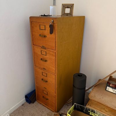 Sale Photo Thumbnail #5: Vintage mid-century oak four-drawer vertical file cabinet with metal brass-toned pulls and label holders.
