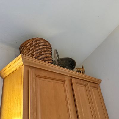 Sale Photo Thumbnail #32: Collection of woven baskets displayed on top of a light wood armoire.