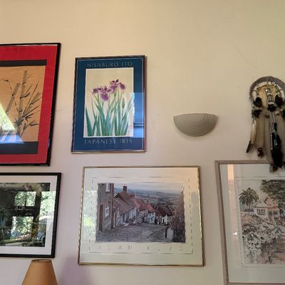 Sale Photo Thumbnail #58: Collection of framed art prints including Asian watercolor styles, landscape photographs, and a Native American-style dreamcatcher hanging on a gallery wall.