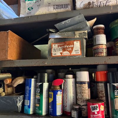 Sale Photo Thumbnail #77: Workshop shelves filled with various hardware supplies, aerosol spray cans, DAP glazing compound, WD-40, and assorted storage boxes.
