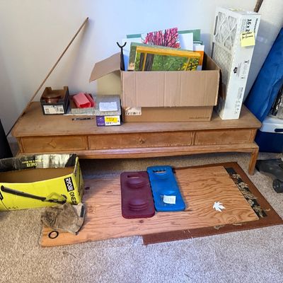 Sale Photo Thumbnail #6: Low wooden bench table holding cardboard boxes of art supplies, framed canvases, air filters, and miscellaneous household items.