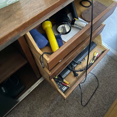 Sale Photo Thumbnail #66: Open wooden cabinet drawers containing flashlights, batteries, and Sony AV equipment cables.