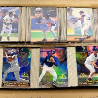 Sale Photo Thumbnail #13: Cardboard storage box filled with late 1990s baseball trading cards, featuring prominent 1997 Flair Showcase cards including Derek Jeter, Alex Rodriguez, and Andruw Jones.