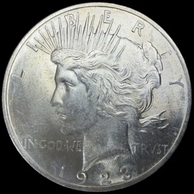 Sale Photo Thumbnail #25: Obverse side of a 1923 United States Peace silver dollar coin featuring Lady Liberty.